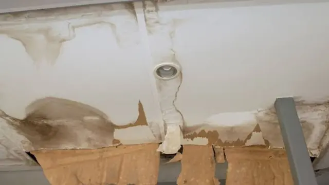 Water-stained ceiling with peeling paint around a light fixture